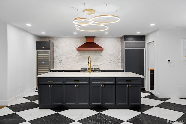 kitchen featuring baseboards, wall chimney exhaust hood, hanging light fixtures, and recessed lighting