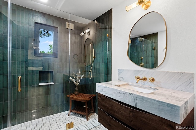 bathroom with tiled shower and vanity