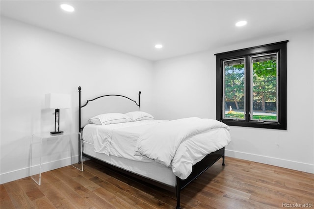 bedroom with recessed lighting, baseboards, and wood finished floors