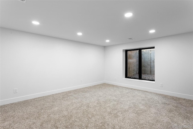 carpeted spare room featuring recessed lighting, visible vents, and baseboards