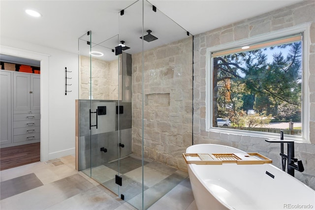 full bathroom with a stall shower, plenty of natural light, and a freestanding tub