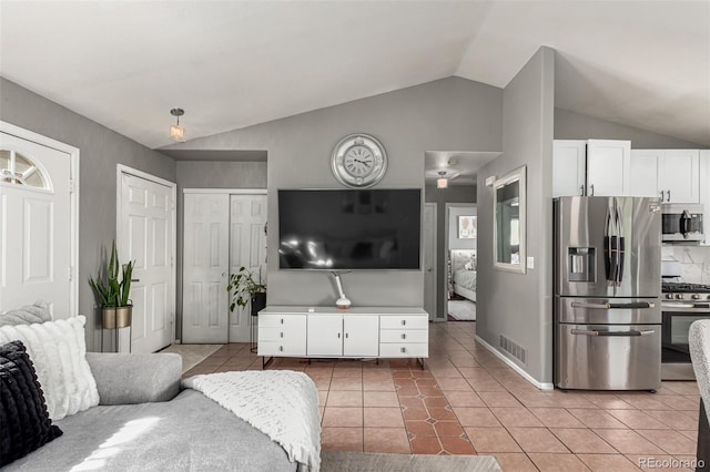 3296 S Bryant St, Englewood, CO 80110 - living room with lofted ceiling, light tile patterned floors, and baseboards