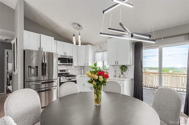 3296 S Bryant St, Englewood, CO 80110 - kitchen featuring appliances with stainless steel finishes, tasteful backsplash, white cabinets, vaulted ceiling, and light countertops