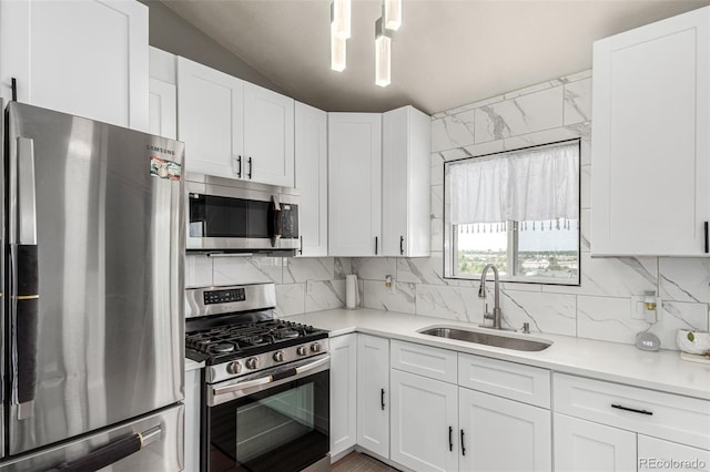 3296 S Bryant St, Englewood, CO 80110 - kitchen with stainless steel appliances, a sink, light countertops, white cabinetry, and vaulted ceiling