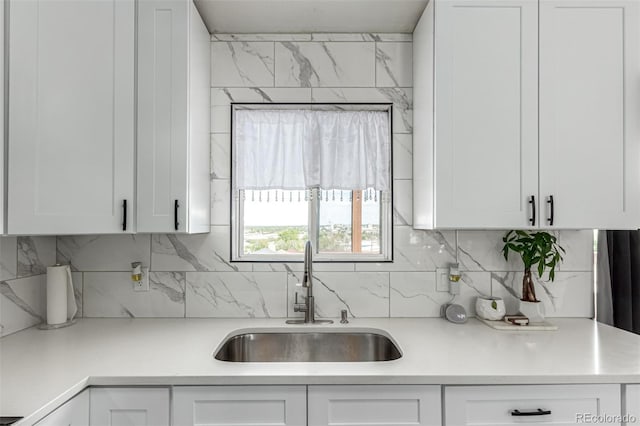 3296 S Bryant St, Englewood, CO 80110 - kitchen with a sink, decorative backsplash, and white cabinetry