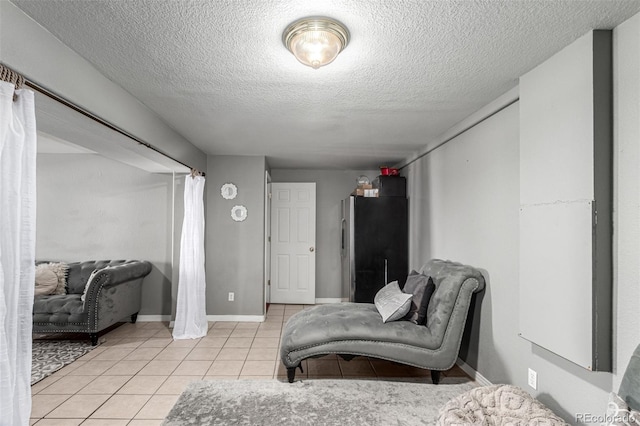 3296 S Bryant St, Englewood, CO 80110 - bedroom with freestanding refrigerator, light tile patterned floors, a textured ceiling, and baseboards