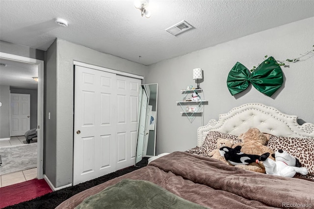 3296 S Bryant St, Englewood, CO 80110 - carpeted bedroom featuring a closet, tile patterned floors, baseboards, and a textured ceiling