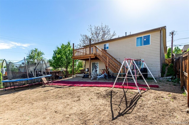 3296 S Bryant St, Englewood, CO 80110 - rear view of house with a trampoline, a patio area, a fenced backyard, a deck, and stairs