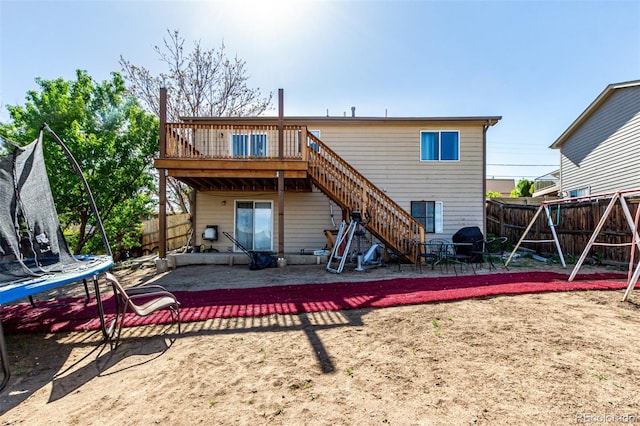 3296 S Bryant St, Englewood, CO 80110 - rear view of property with a trampoline, a fenced backyard, stairs, a deck, and a patio