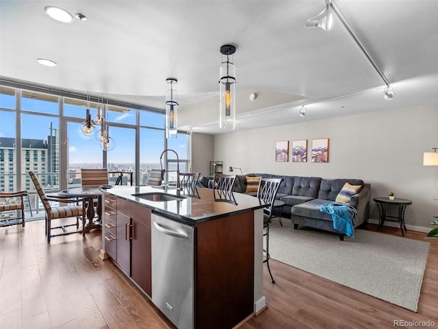891 14th St Unit 3410, Denver, CO 80202 - kitchen with stainless steel dishwasher, dark wood-style floors, open floor plan, a breakfast bar area, and an island with sink