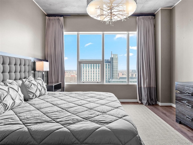 891 14th St Unit 3410, Denver, CO 80202 - bedroom featuring a chandelier, a city view, ornamental molding, and wood finished floors