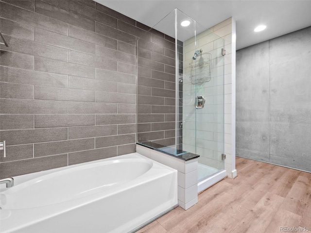 891 14th St Unit 3410, Denver, CO 80202 - full bath featuring wood finished floors, a shower stall, a garden tub, and recessed lighting