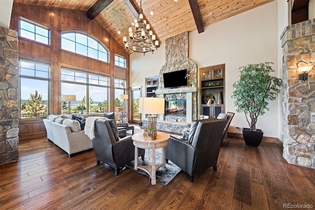 living room featuring high vaulted ceiling, a stone fireplace, beamed ceiling, dark hardwood / wood-style flooring, and a chandelier