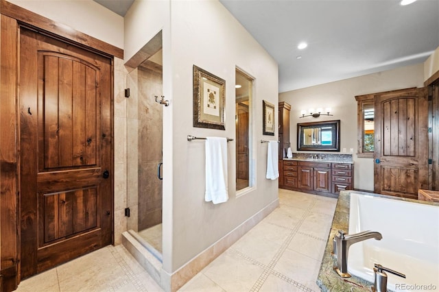 bathroom with vanity and shower with separate bathtub