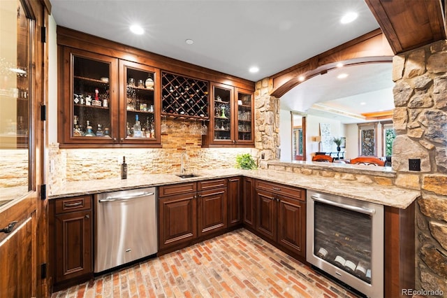 bar featuring wine cooler, light stone counters, dishwasher, and decorative backsplash