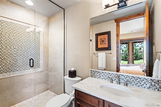 bathroom featuring decorative backsplash, toilet, an enclosed shower, and vanity