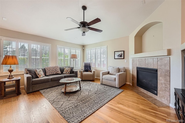23808 E Bellewood Dr, Aurora, CO 80016 - living area featuring light wood finished floors, healthy amount of natural light, a ceiling fan, and a tile fireplace