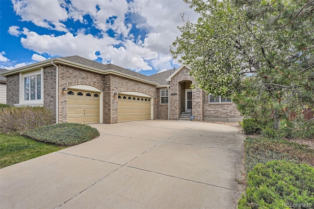 23808 E Bellewood Dr, Aurora, CO 80016 - view of front of home featuring an attached garage, concrete driveway, brick siding, and a shingled roof