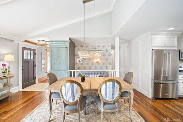 1100 Pontiac St, Denver, CO 80220 - dining room featuring dark wood-type flooring, wallpapered walls, baseboards, lofted ceiling, and a chandelier