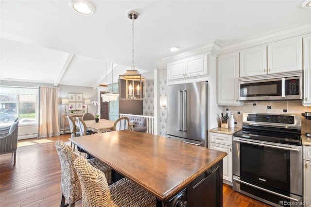 1100 Pontiac St, Denver, CO 80220 - kitchen featuring appliances with stainless steel finishes, dark wood finished floors, white cabinets, backsplash, and a baseboard heating unit
