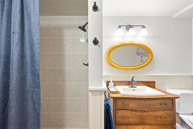 1100 Pontiac St, Denver, CO 80220 - bathroom featuring tiled shower, vanity, a wainscoted wall, and toilet