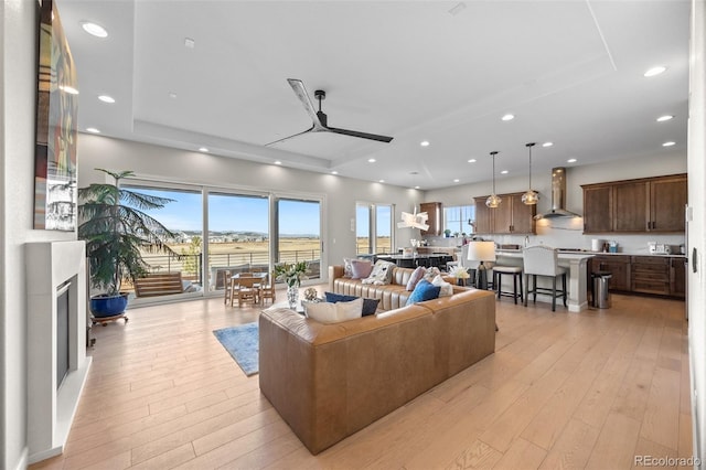 living area with recessed lighting, a wealth of natural light, and light wood-style floors