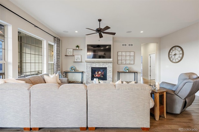 living area featuring ceiling fan, a stone fireplace, recessed lighting, and wood finished floors