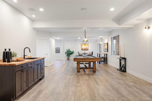 game room featuring recessed lighting, baseboards, a sink, and light wood finished floors