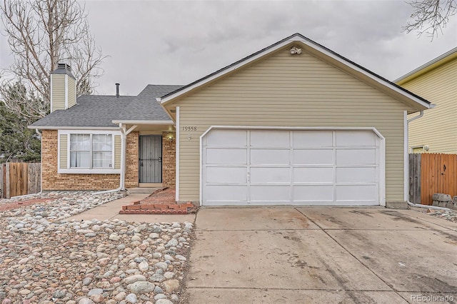 ranch-style house featuring concrete driveway, brick siding, and fence