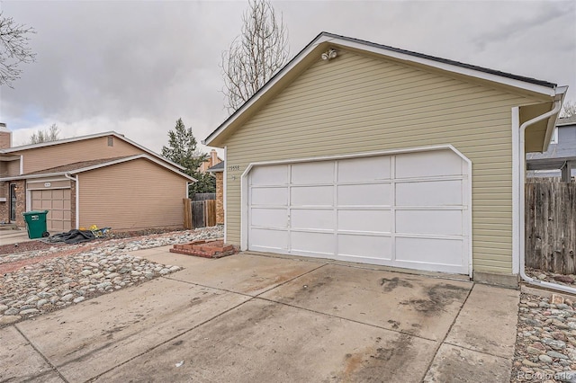 detached garage featuring fence