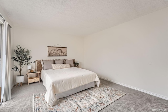 carpeted bedroom with a textured ceiling and baseboards