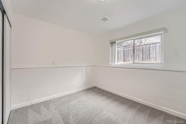 carpeted empty room with baseboards and visible vents