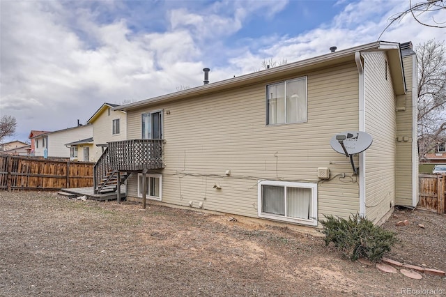 back of property featuring fence and stairs