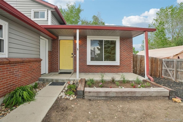 6337 W 68th Pl, Arvada, CO 80003 - doorway to property with fence and brick siding