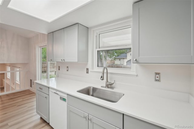 6337 W 68th Pl, Arvada, CO 80003 - kitchen featuring dishwasher, a sink, light countertops, and light wood finished floors