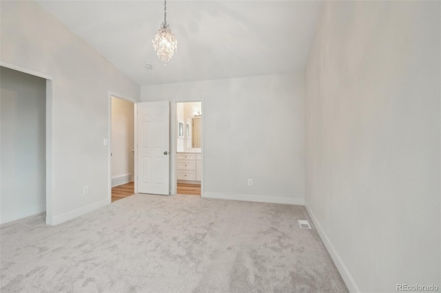 6337 W 68th Pl, Arvada, CO 80003 - unfurnished bedroom with carpet floors, a chandelier, baseboards, and ensuite bath