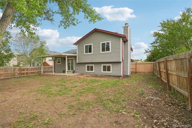 6337 W 68th Pl, Arvada, CO 80003 - back of house featuring a chimney, a fenced backyard, and a patio area