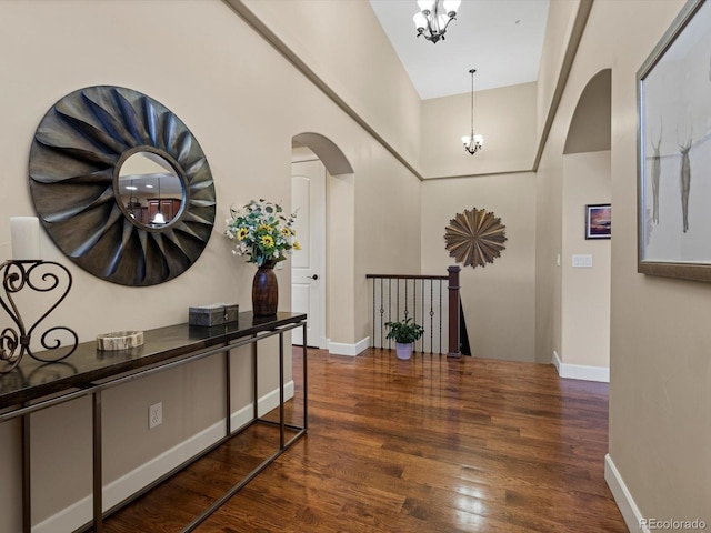 2363 Primo Rd Unit A, Highlands Ranch, CO 80129 - hallway with arched walkways, a chandelier, wood finished floors, and a towering ceiling