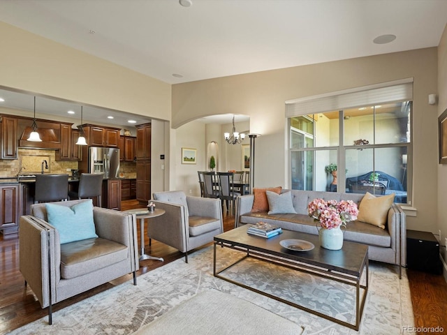 2363 Primo Rd Unit A, Highlands Ranch, CO 80129 - living room featuring wood finished floors, a chandelier, and arched walkways