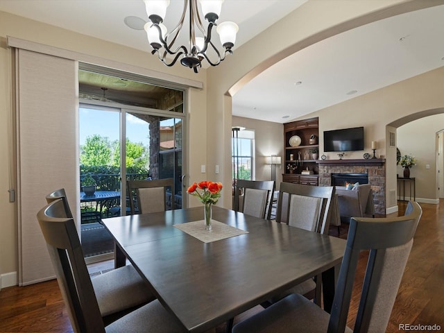 2363 Primo Rd Unit A, Highlands Ranch, CO 80129 - dining space featuring arched walkways, healthy amount of natural light, wood finished floors, and a stone fireplace