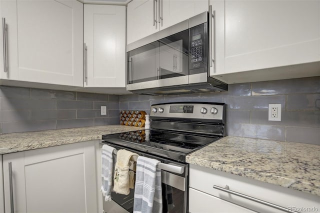 kitchen with decorative backsplash, white cabinetry, and appliances with stainless steel finishes