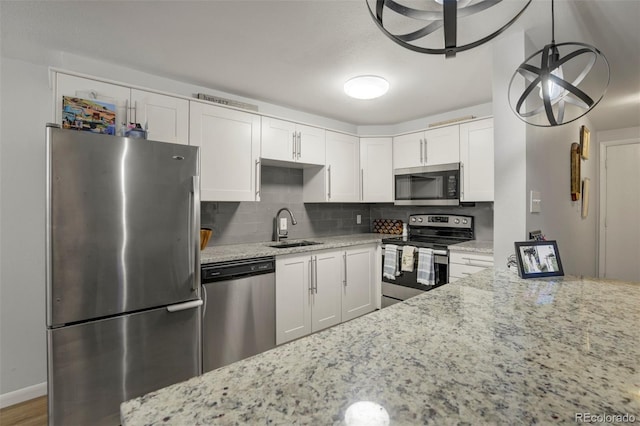kitchen featuring a sink, tasteful backsplash, light stone countertops, and stainless steel appliances