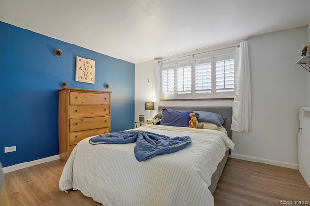 bedroom with baseboards and wood finished floors