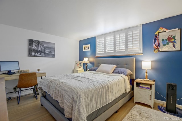 bedroom with baseboards and wood finished floors