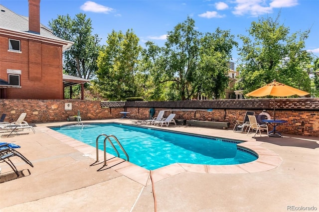 community pool with fence and a patio area