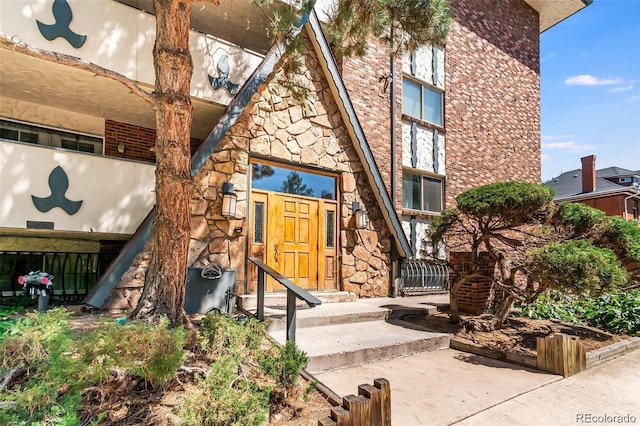 entrance to property featuring stone siding