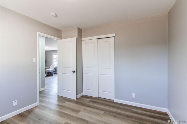 unfurnished bedroom with hardwood / wood-style flooring and a closet