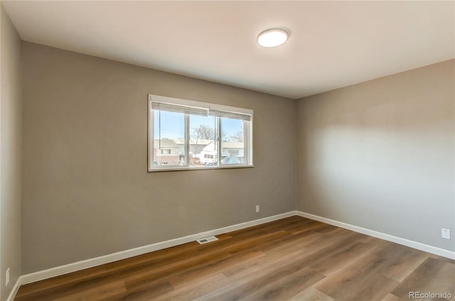 unfurnished room with hardwood / wood-style flooring