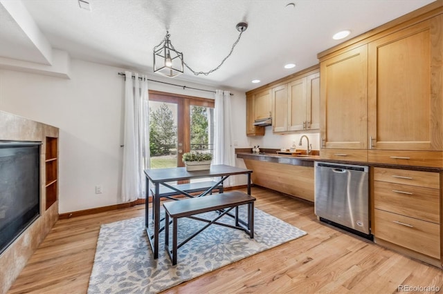 kitchen with pendant lighting, sink, stainless steel dishwasher, light wood-type flooring, and light brown cabinetry