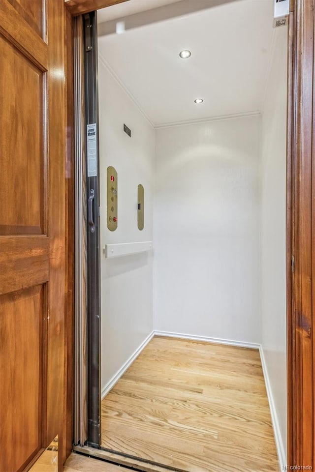 interior details with elevator and hardwood / wood-style floors